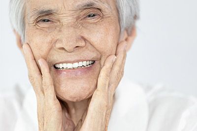 woman smiling with dental implants from Pearl Dentistry